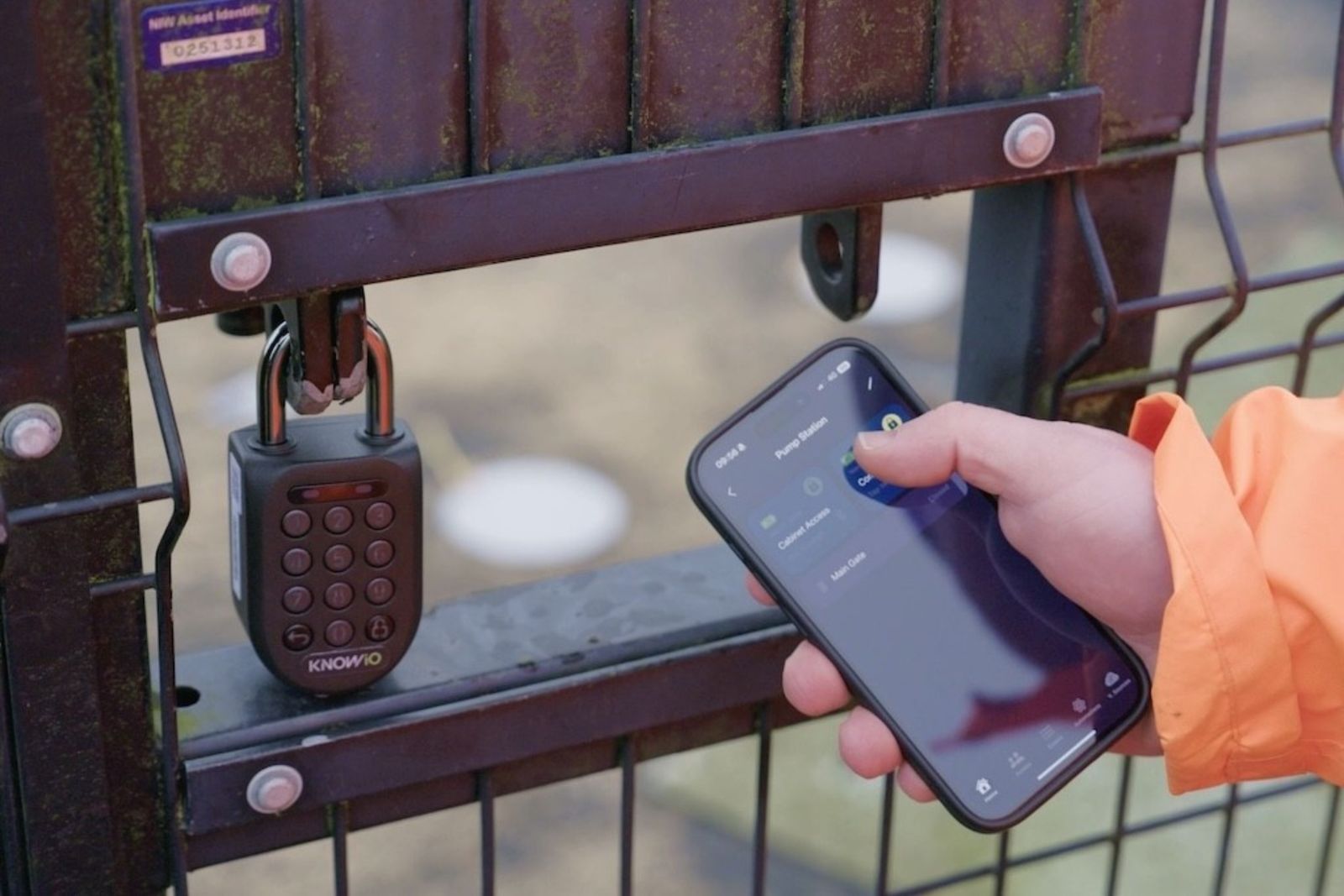 Smart padlock on a site gate being opened from a smartphone